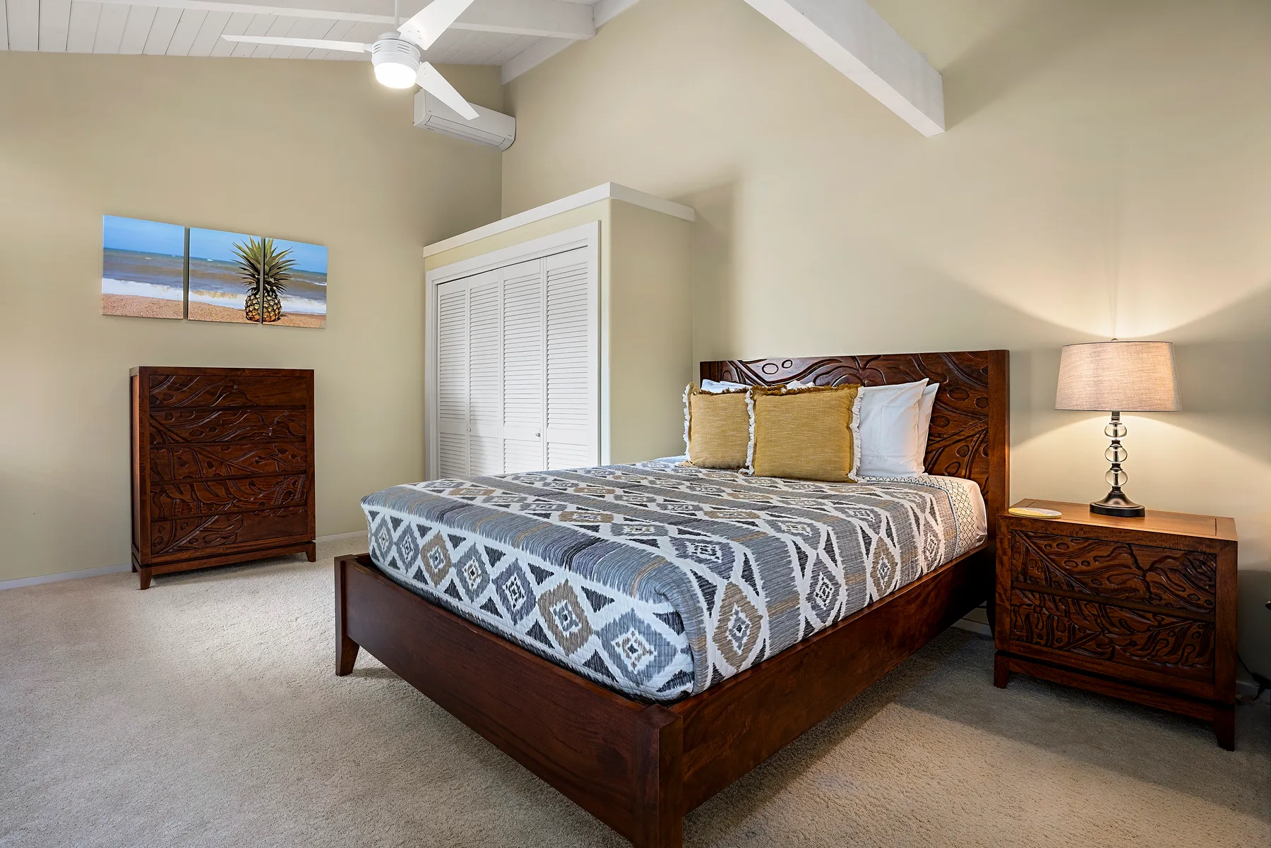 Un dormitorio con una colcha estampada y muebles de madera a juego junto a la cama.