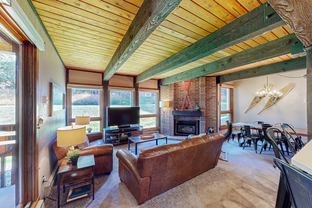 A living room with a seating area, fireplace, and dining table.