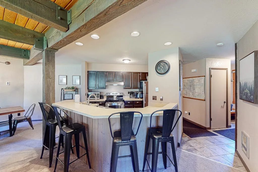 An open kitchen and dining area with a raised counter and bar seating.