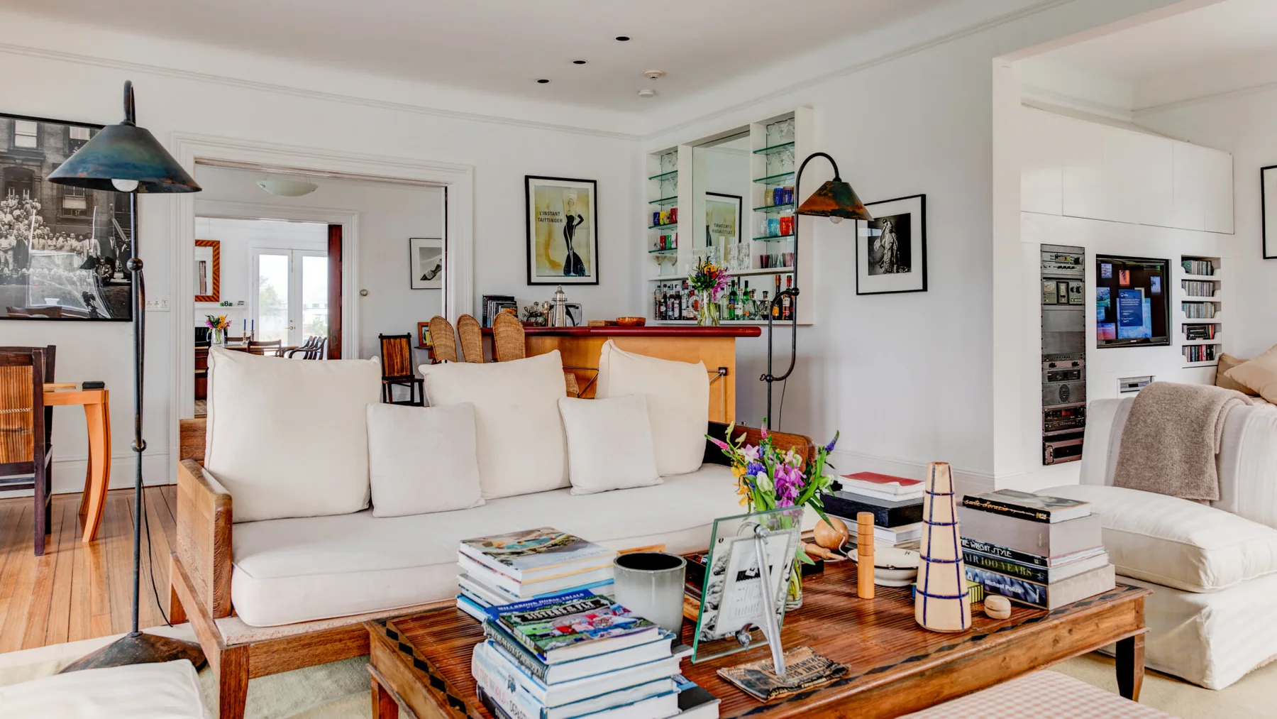 Una sala luminosa con asientos blancos y una mesa de centro de madera.