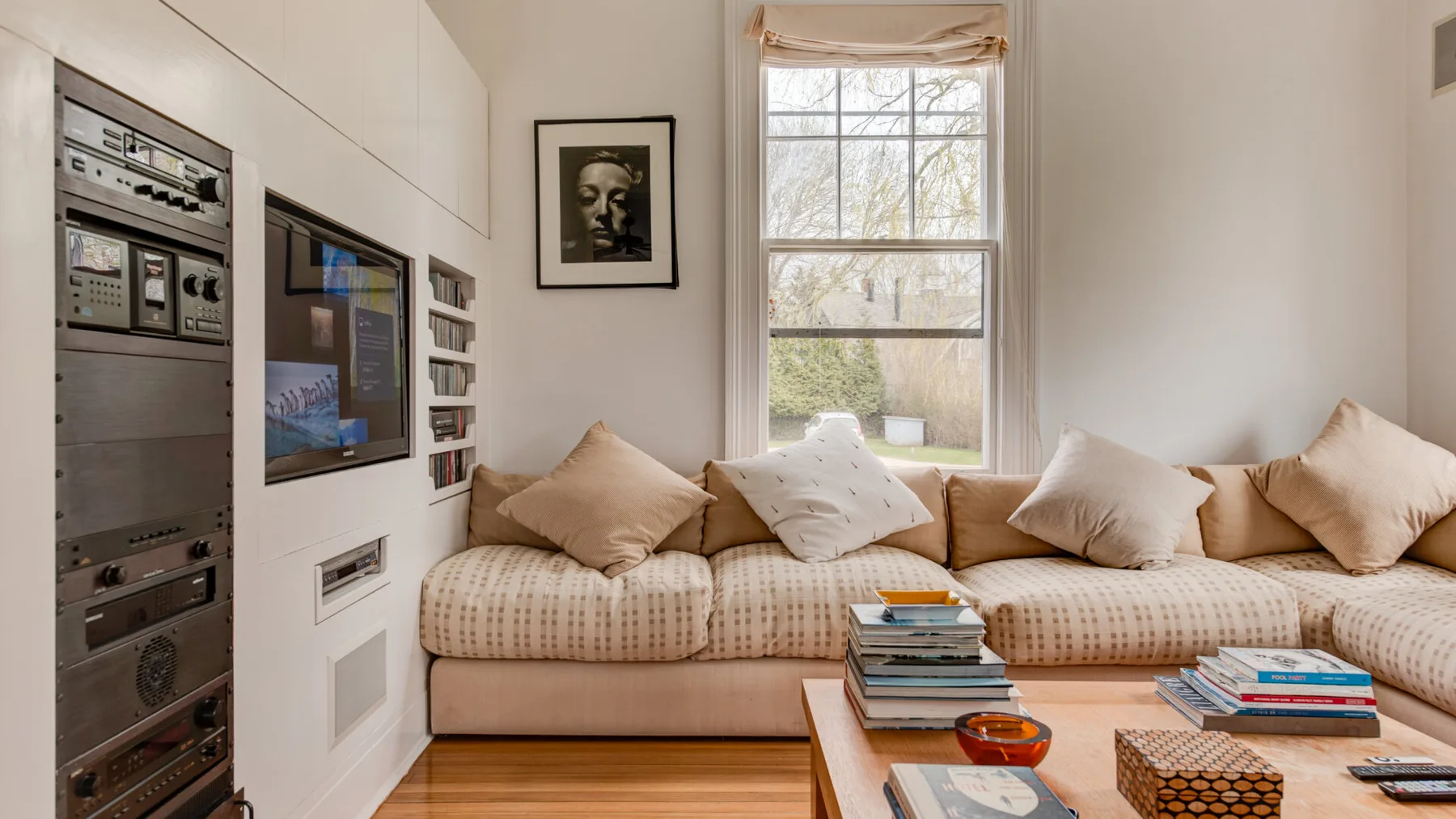 Una sala de estar con un asiento junto a la ventana y una mesa de centro baja.