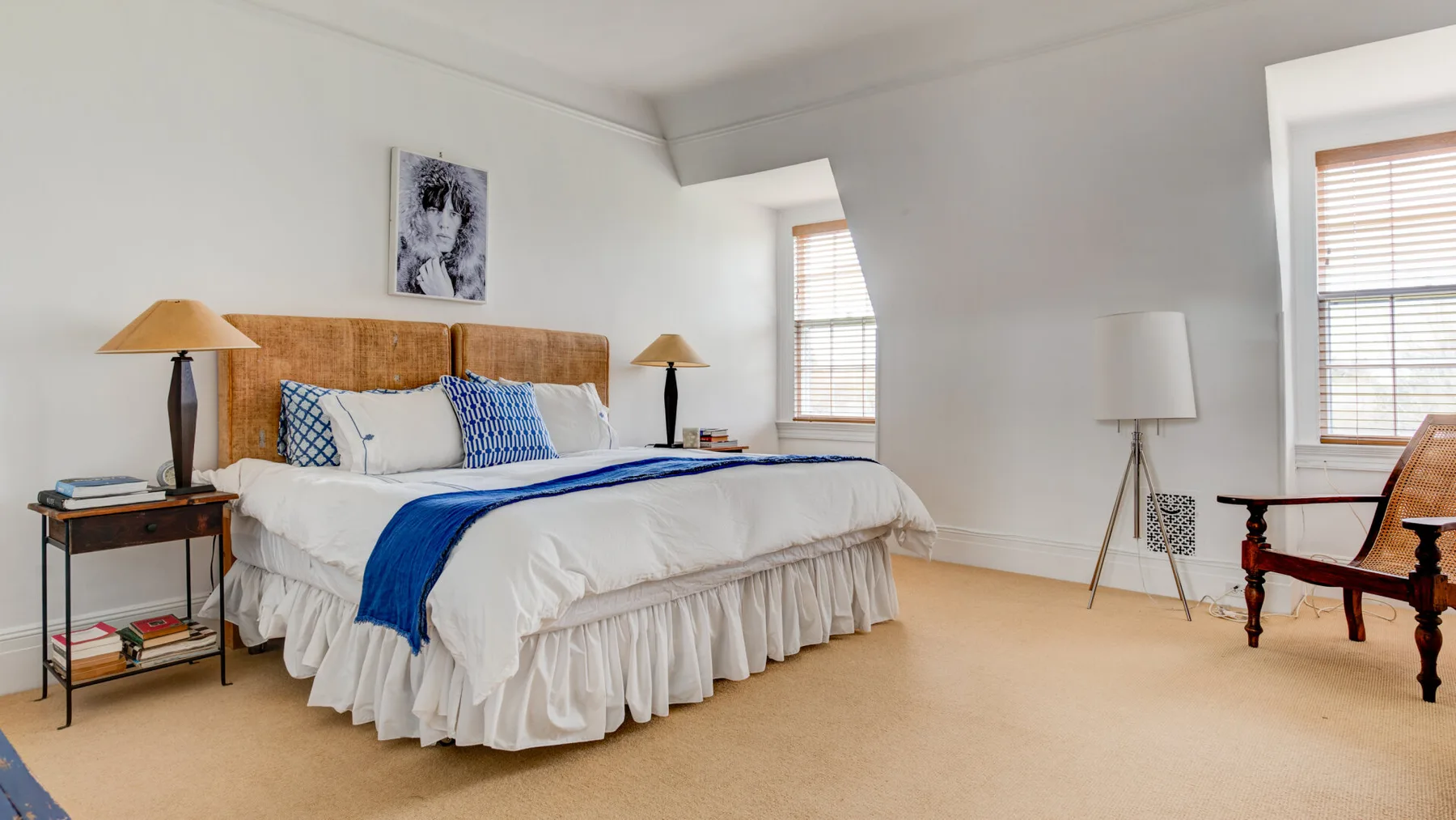 Un dormitorio luminoso con una cama grande y ventanas.