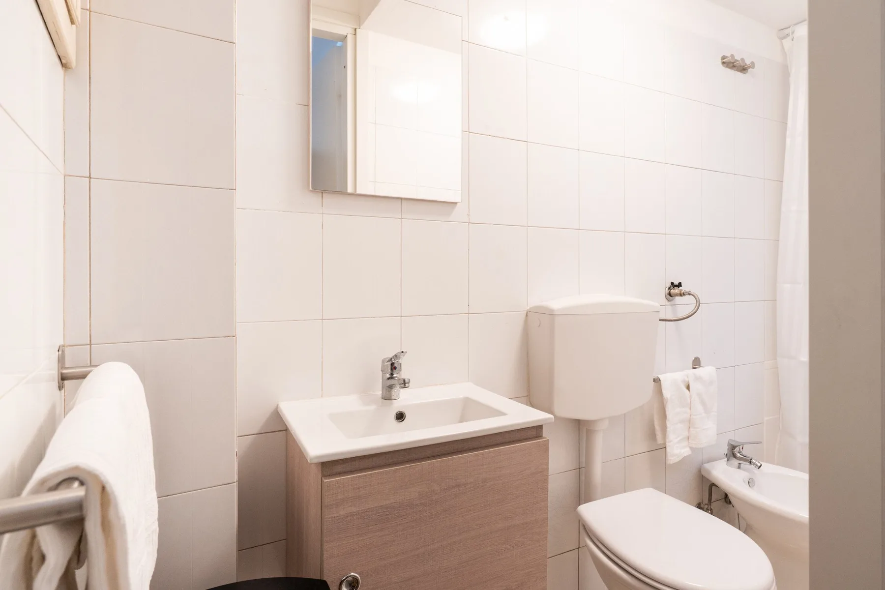 Un baño alicatado con lavabo, inodoro y bidé.