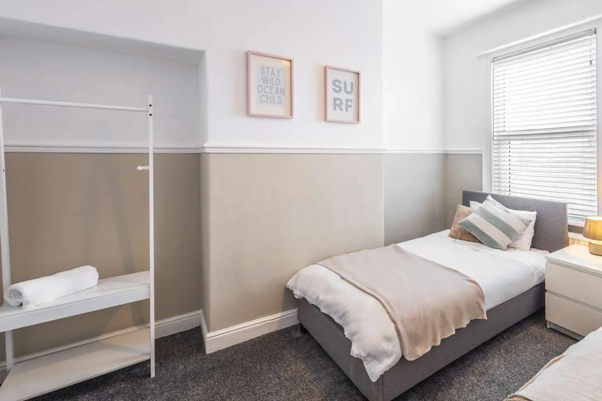 Un dormitorio con una cama junto a una ventana con persianas.