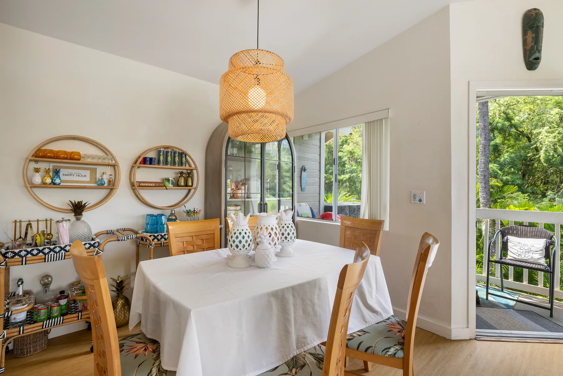 A dining area with a table set beneath a woven pendant light.