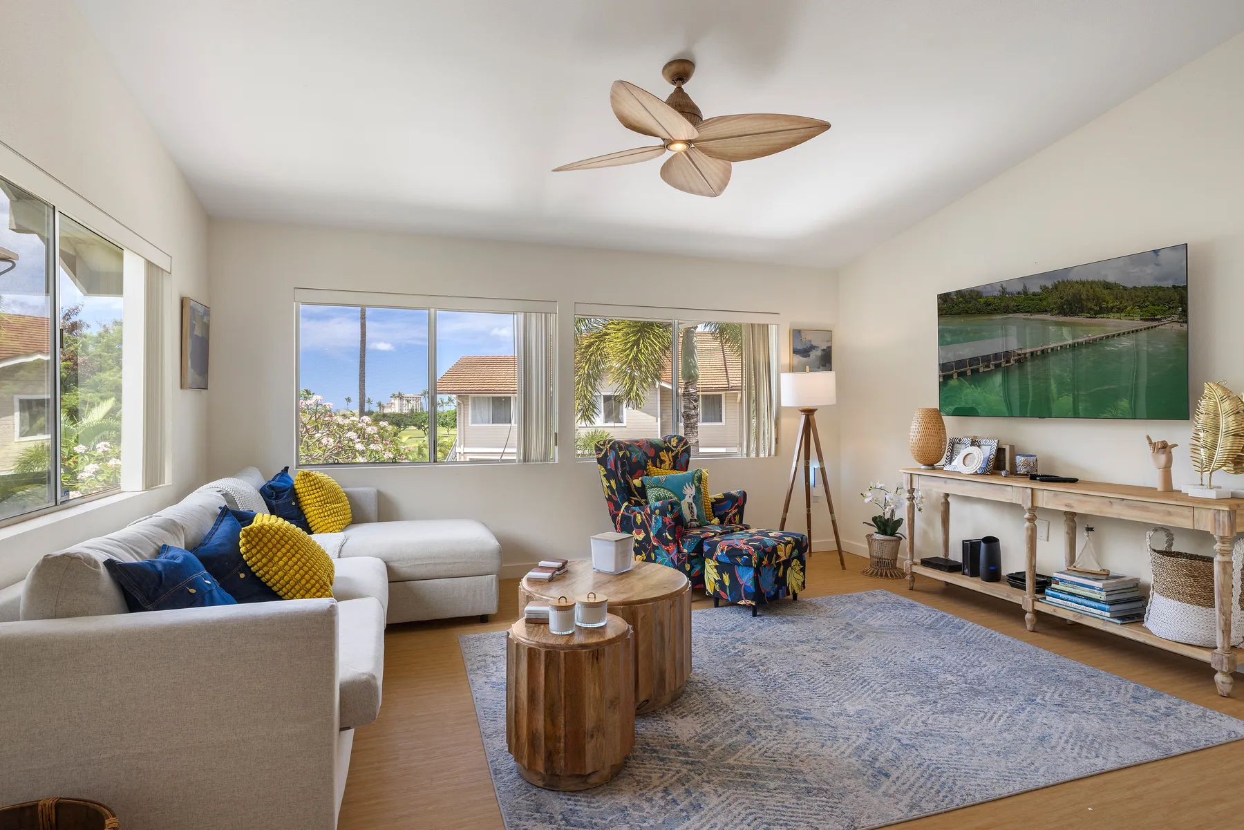 A bright living room with seating, a coffee table, and large windows.