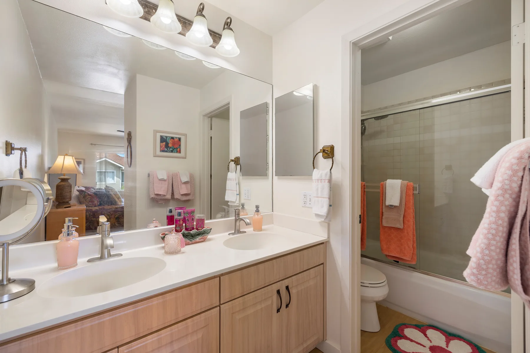 A bathroom vanity with sinks and a bathtub beside it.