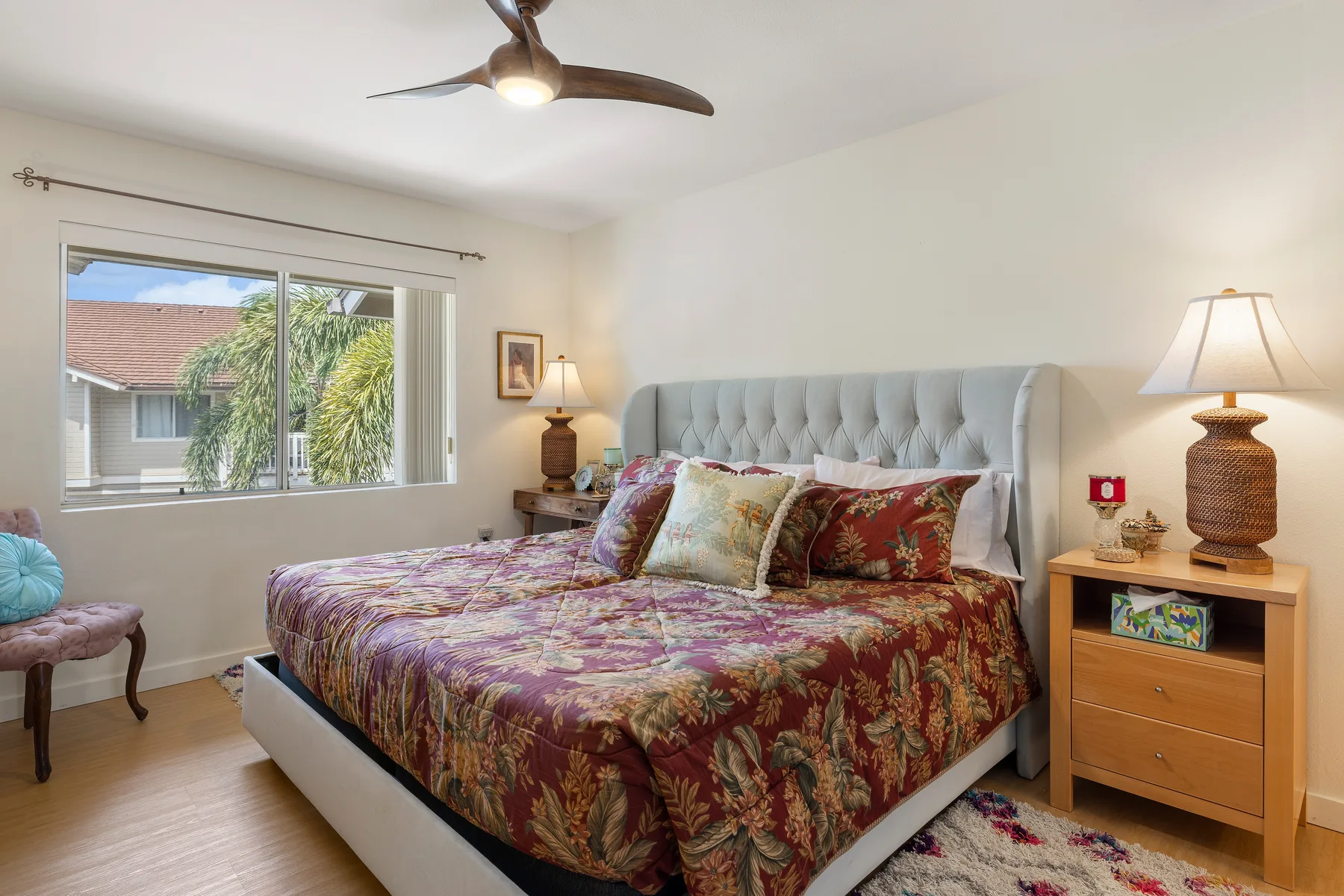 A bedroom with a large bed, patterned bedding, and a window.