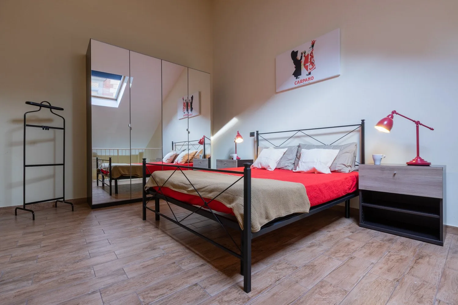 Un dormitorio con una cama doble, un armario con espejo y lámparas de mesita.