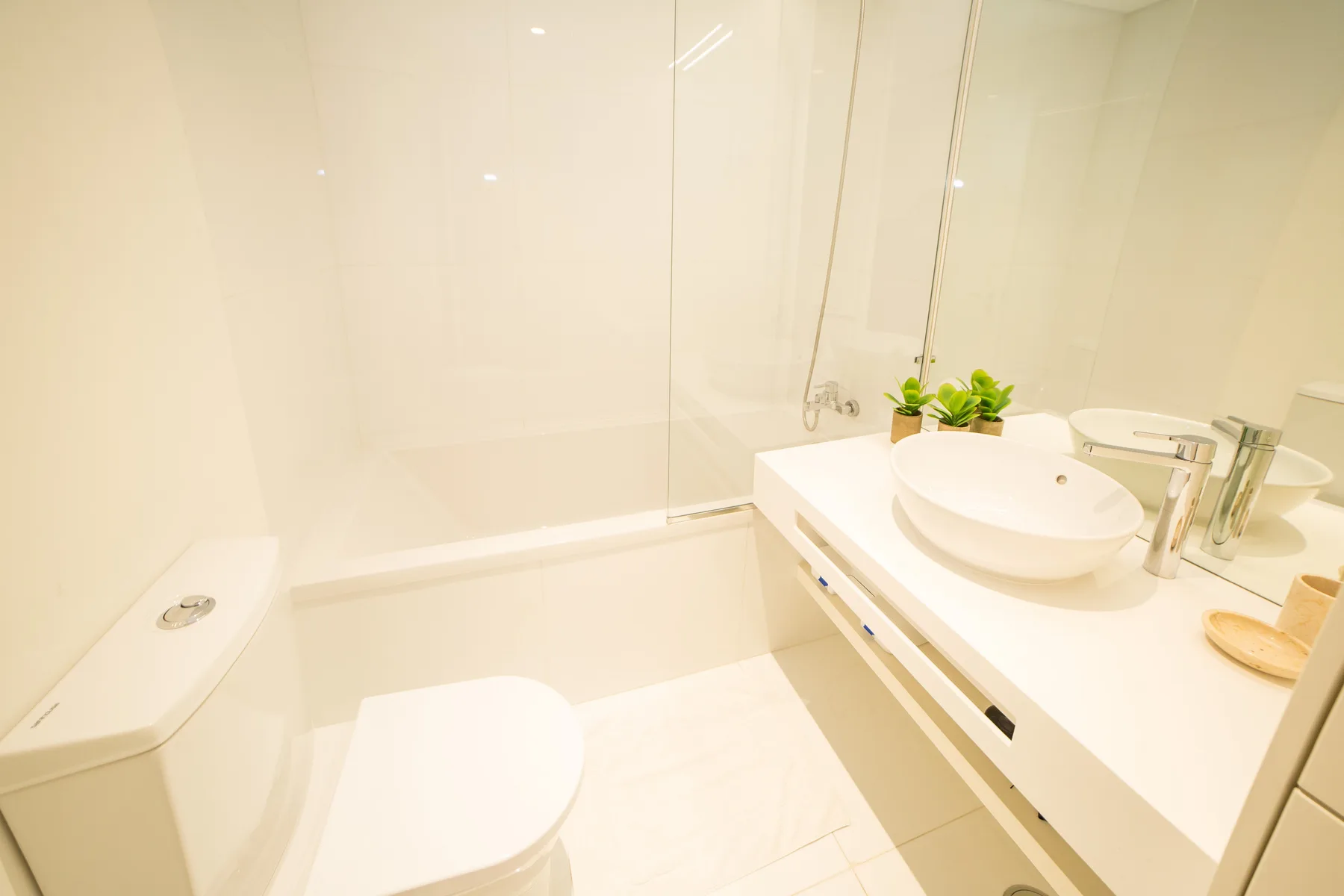 Un baño luminoso con bañera, inodoro y lavabo.