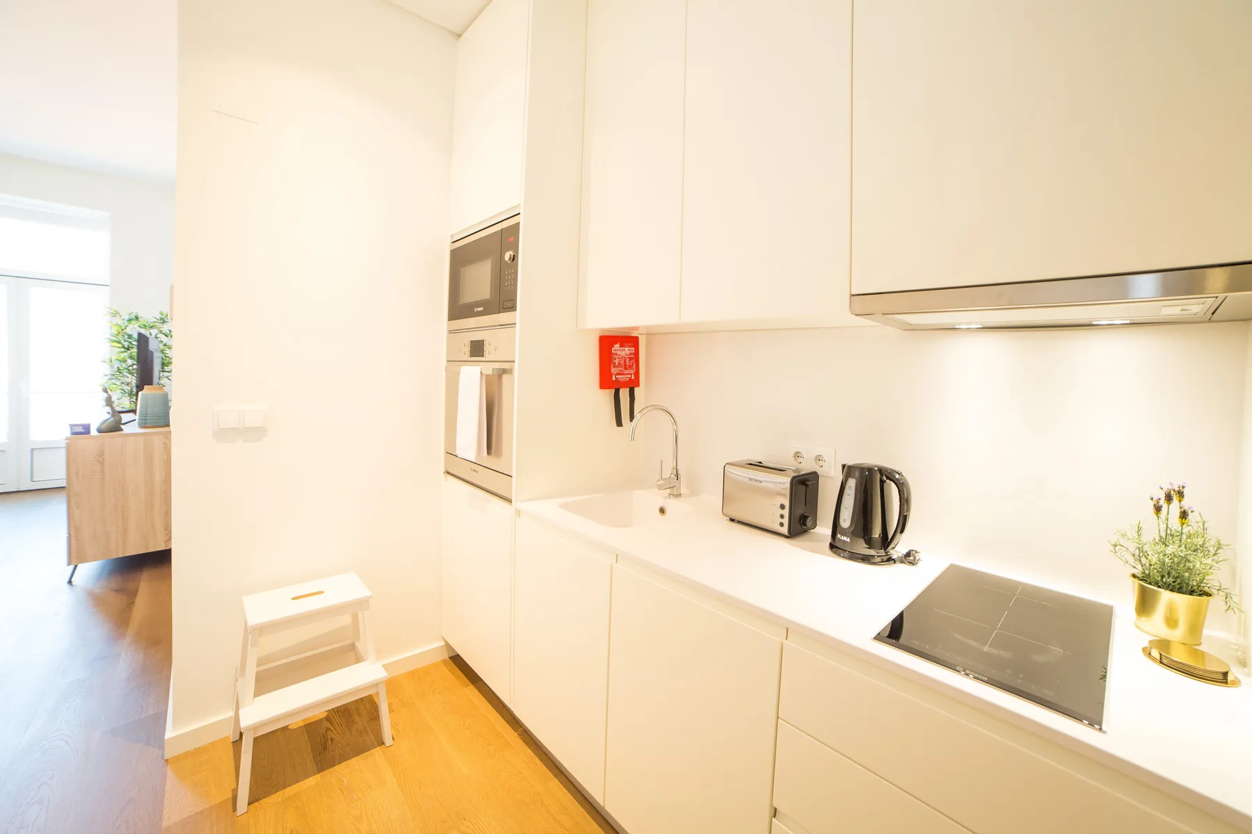 Una cocina moderna y luminosa con placa de cocción, tostadora y hervidor.