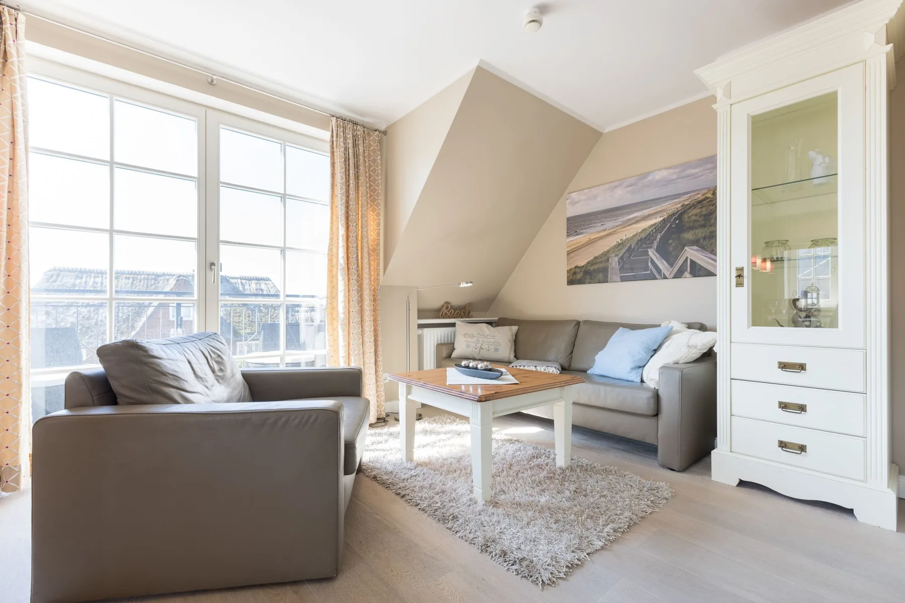 Una sala luminosa con asientos junto a grandes ventanas y una mesa de centro.