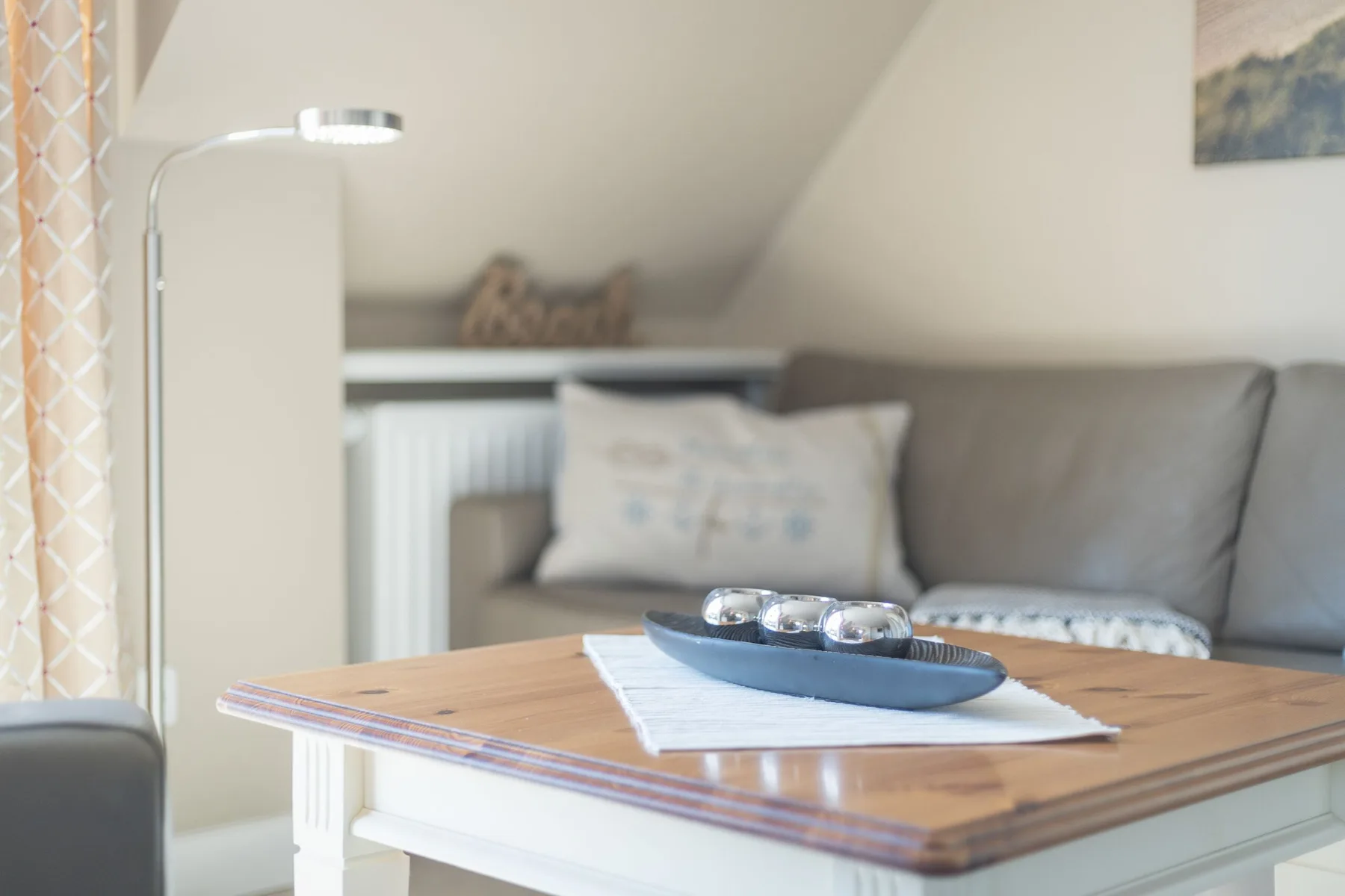 Una sala de estar con un sofá gris y una mesa de centro de madera.