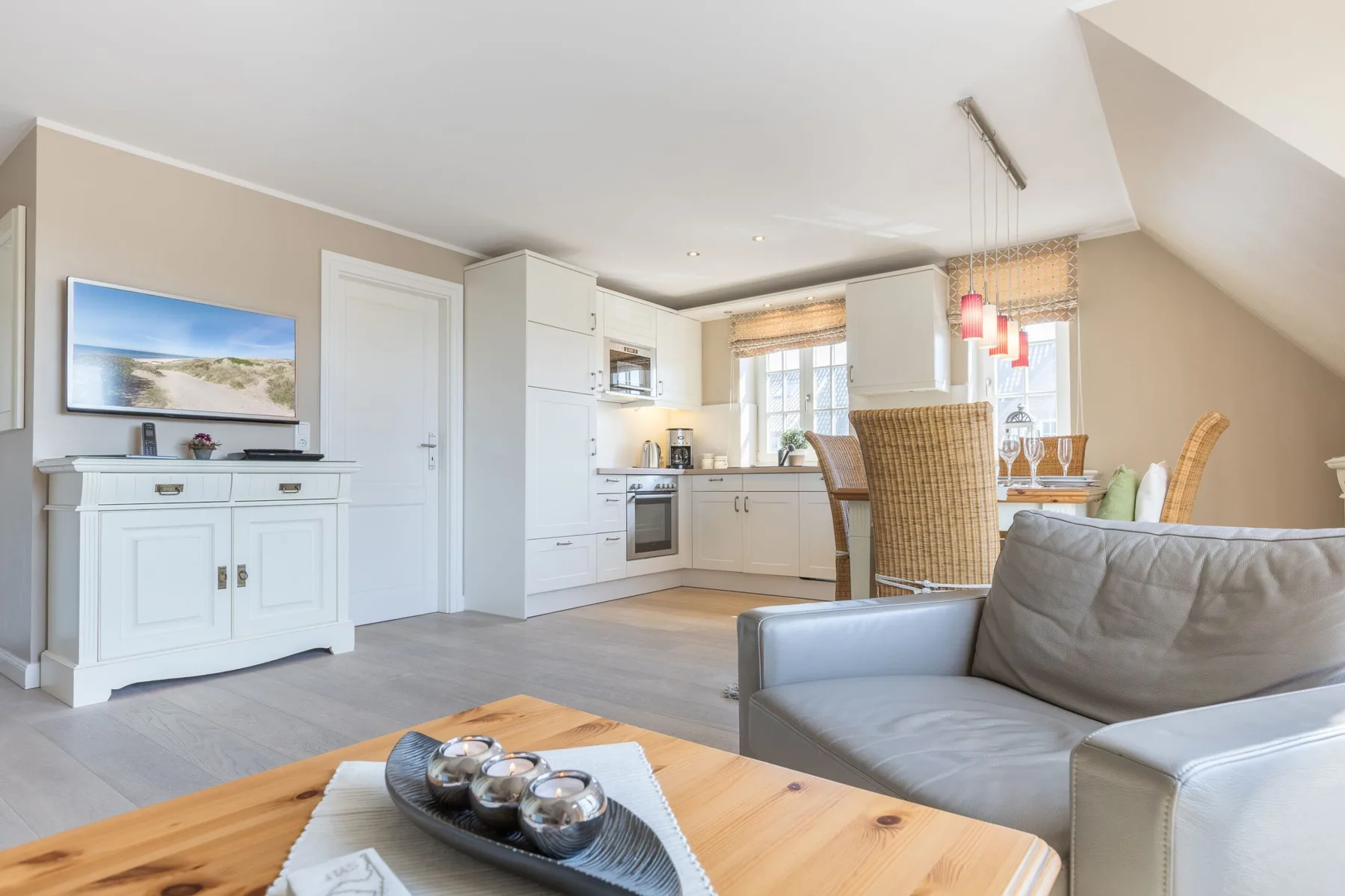 Sala de estar y cocina de concepto abierto con mesa de comedor y asientos.