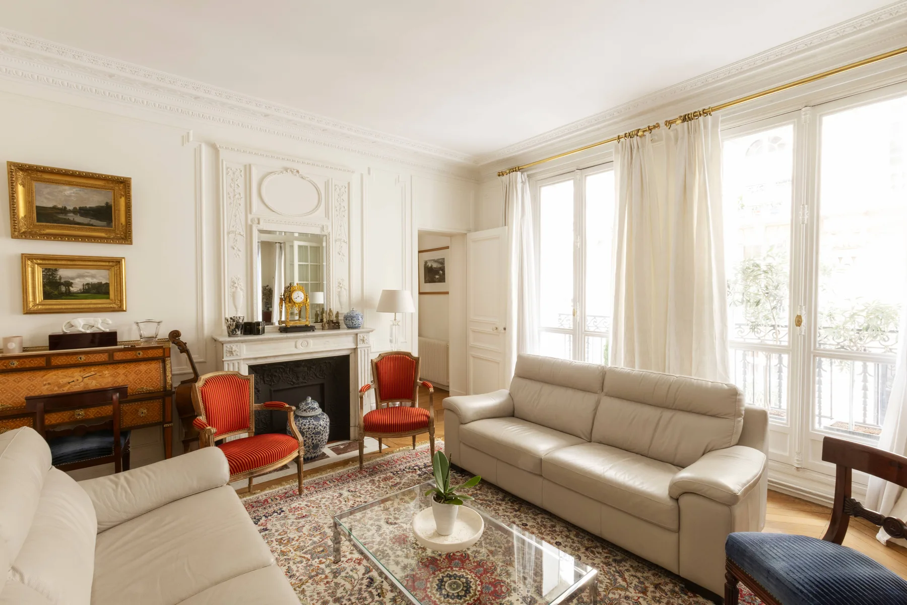A bright living room with neutral seating and tall windows.