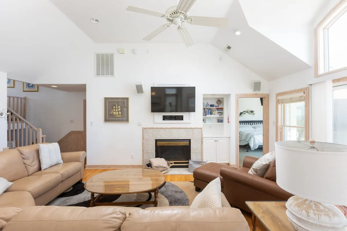 Una sala luminosa con asientos, una chimenea y un televisor.
