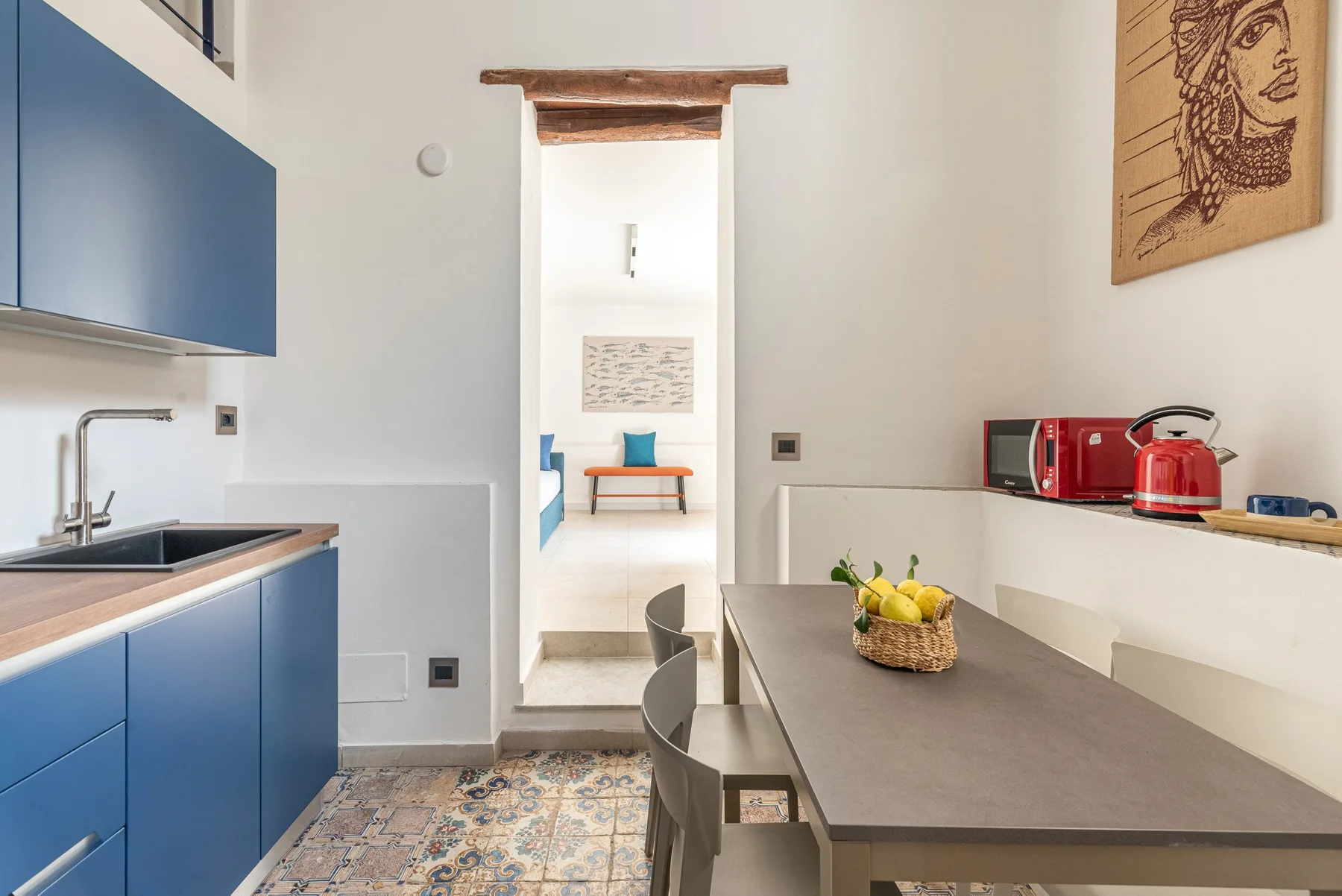 Una cocina y zona de comedor con armarios azules y una mesa.