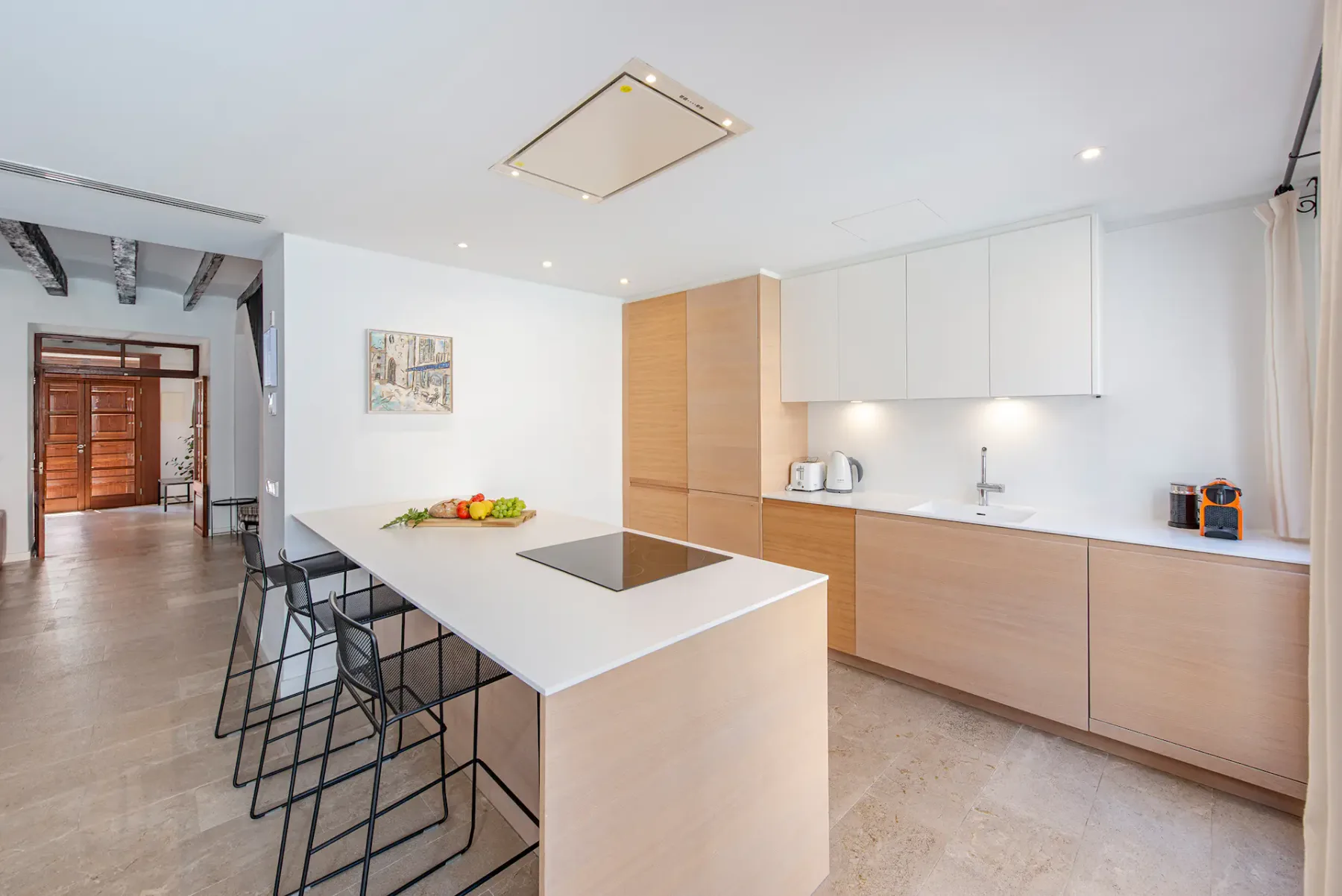 A bright modern kitchen with a central island and bar seating.