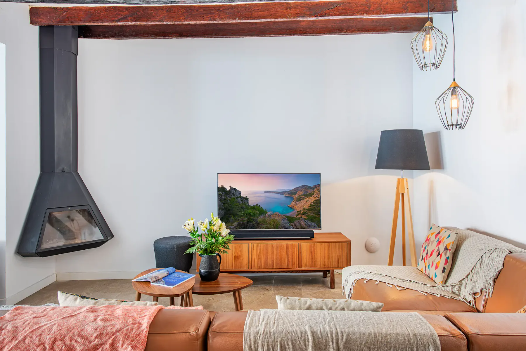 A living room with seating, a fireplace, and a television.