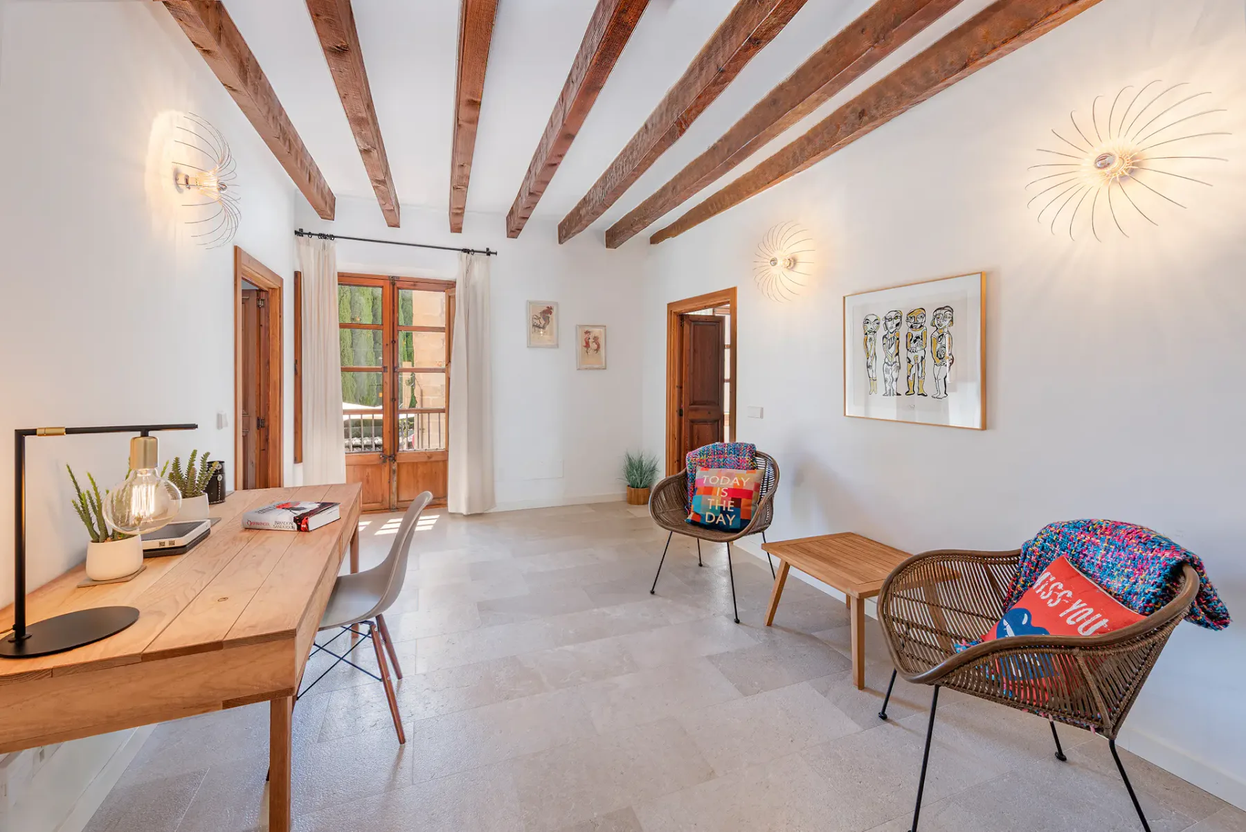 A bright living room with exposed wooden ceiling beams and a seating area.
