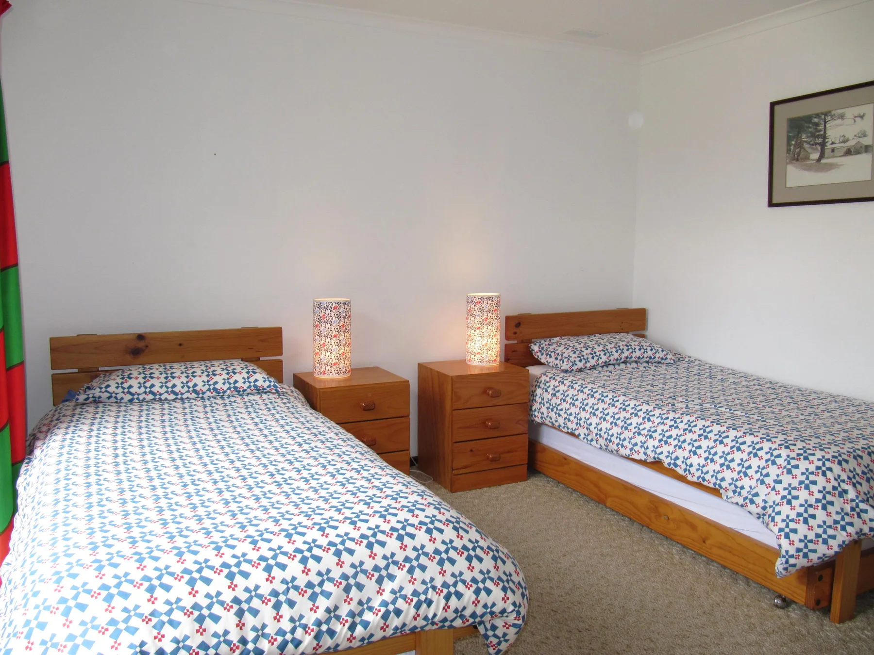 A bedroom with two beds and matching patterned bedding.