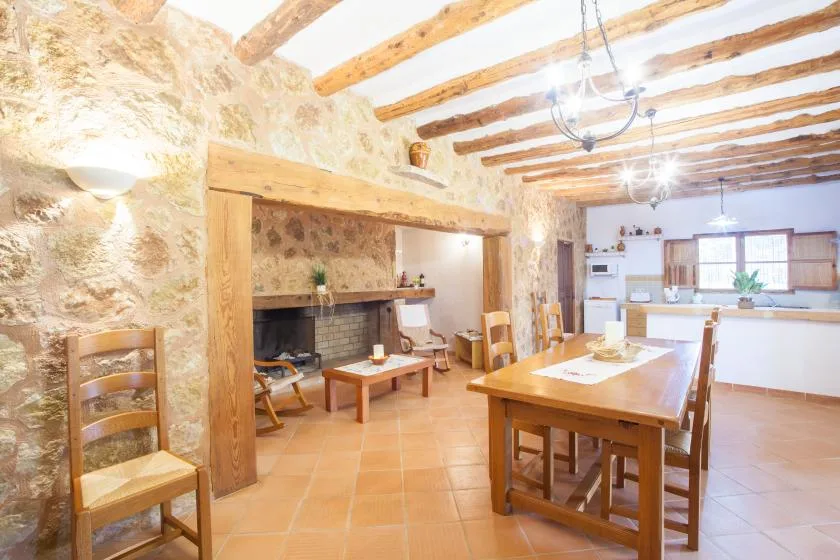 A rustic dining room with a long wooden table and exposed ceiling beams.