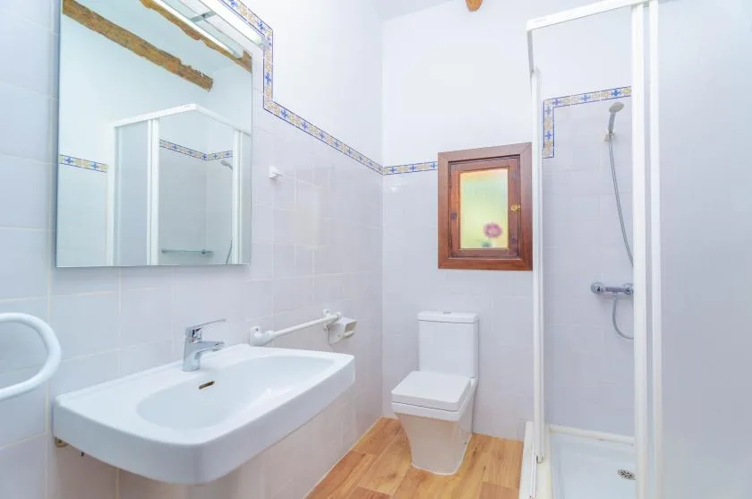 A bright bathroom with a sink, toilet, and shower.