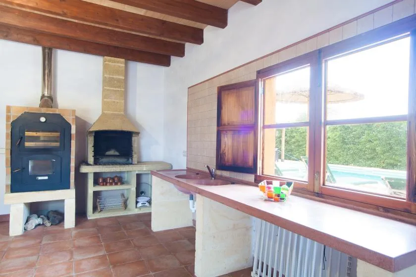 A bright kitchen area with a counter, large windows, and built-in cooking appliances.