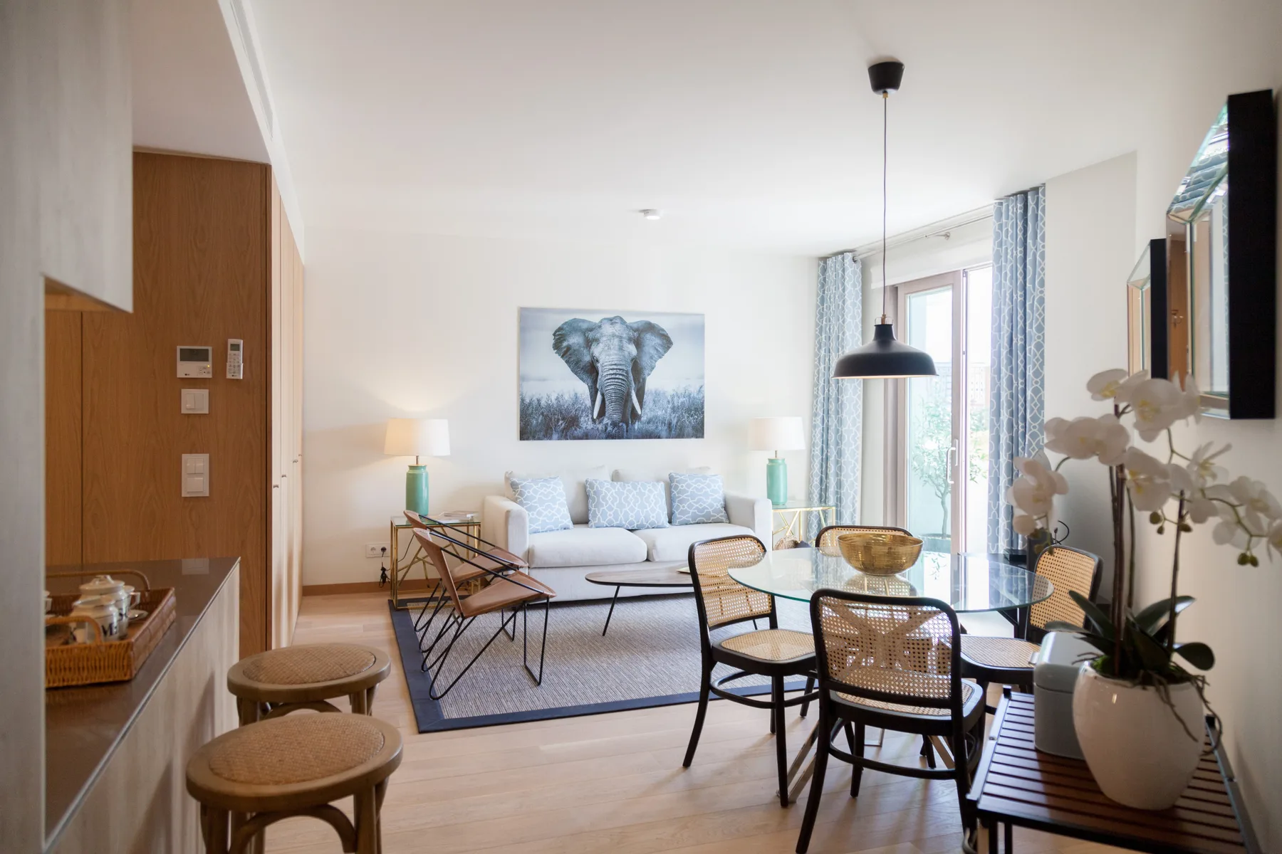 A bright living room with seating around a glass dining table.