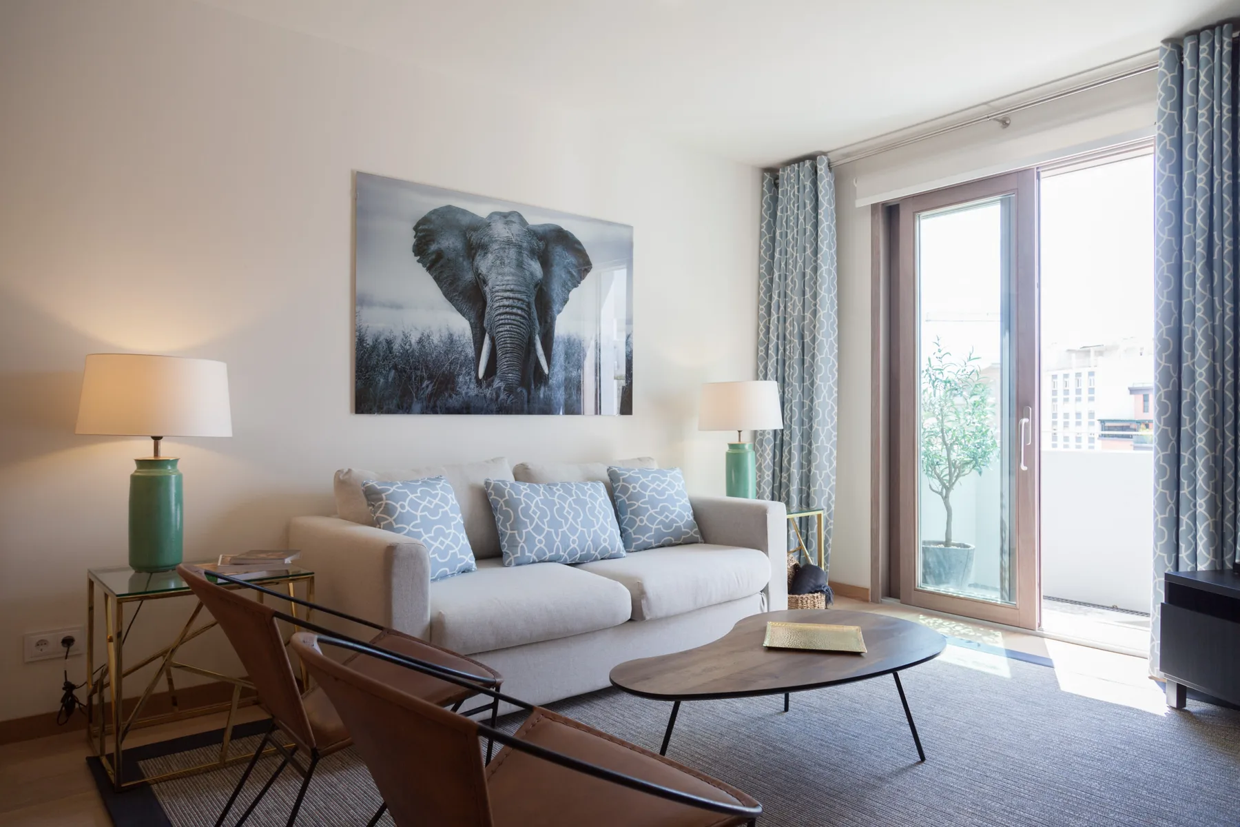 A living room with a sofa, a coffee table, and a large window.