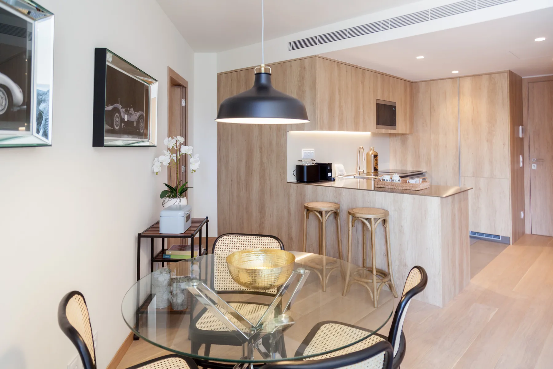 An open-plan kitchen and dining area with a counter and glass dining table.