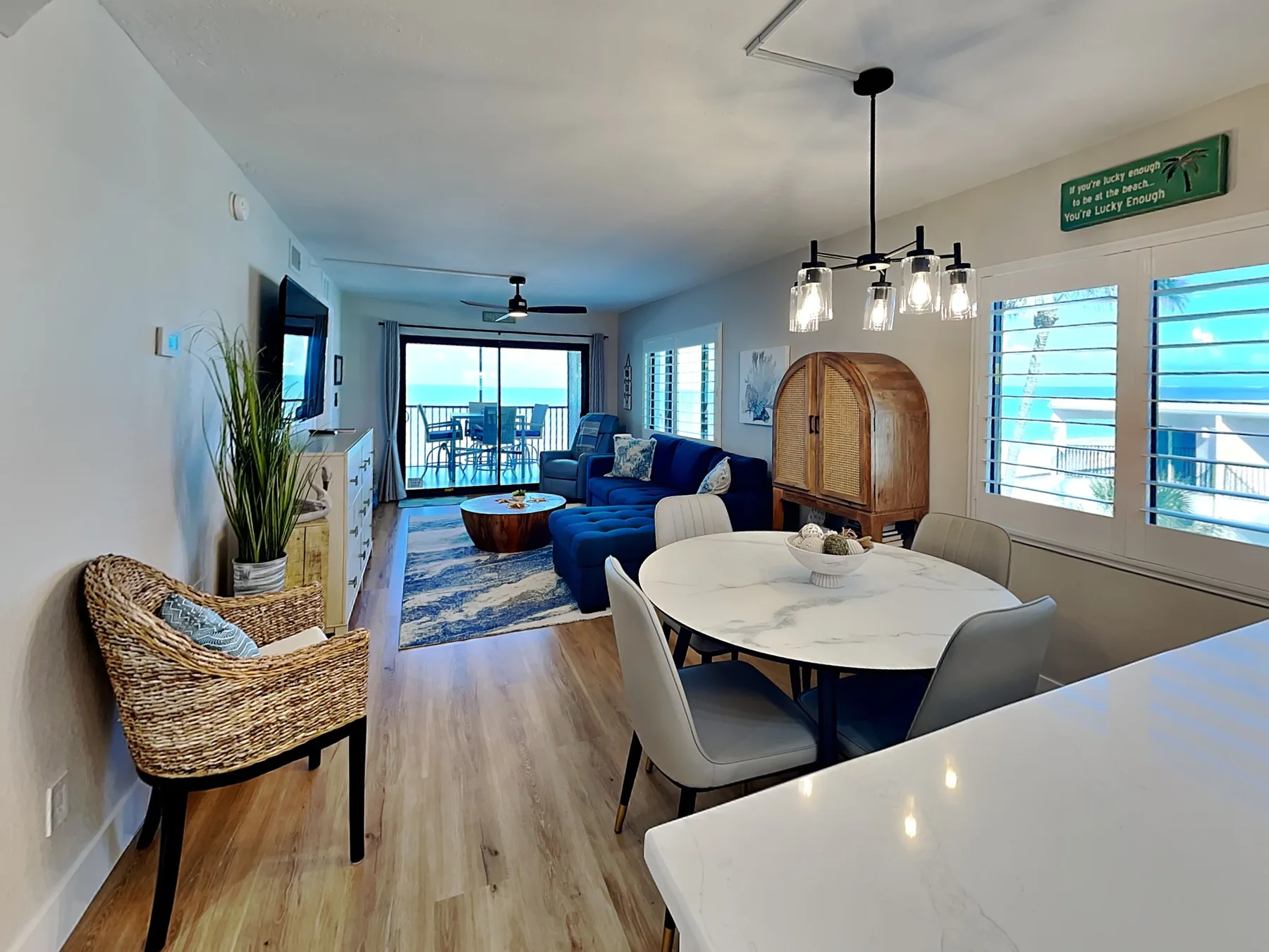 An open-plan living and dining area with a blue seating group and a round dining table.