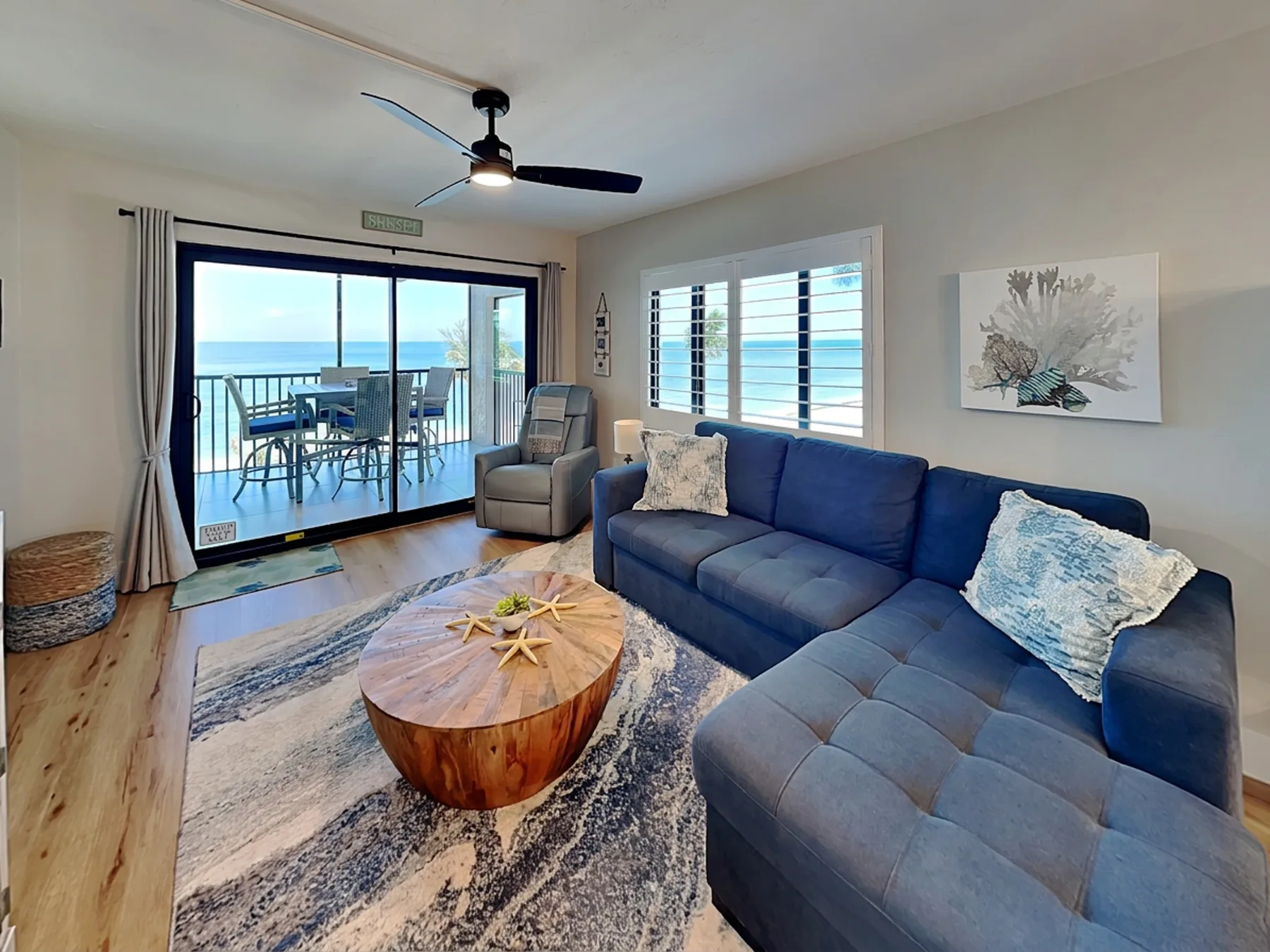 Living room with blue seating, a coffee table, and sliding doors to a patio.