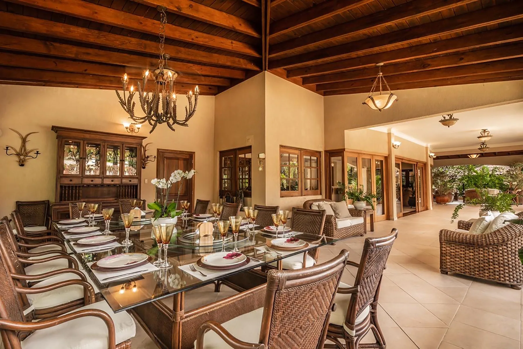 A spacious dining area with a long table beneath a wood-beamed ceiling.