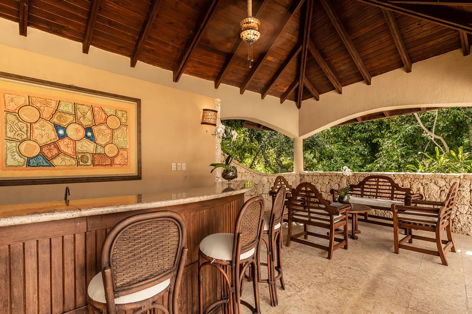 A covered outdoor dining area with wooden seating and a long counter.