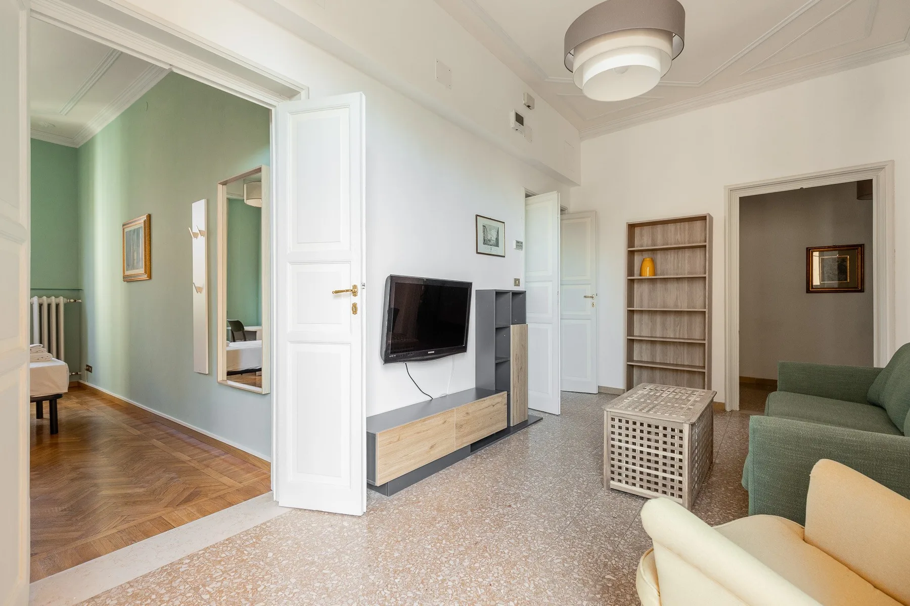A bright living room with a wall-mounted television and seating.
