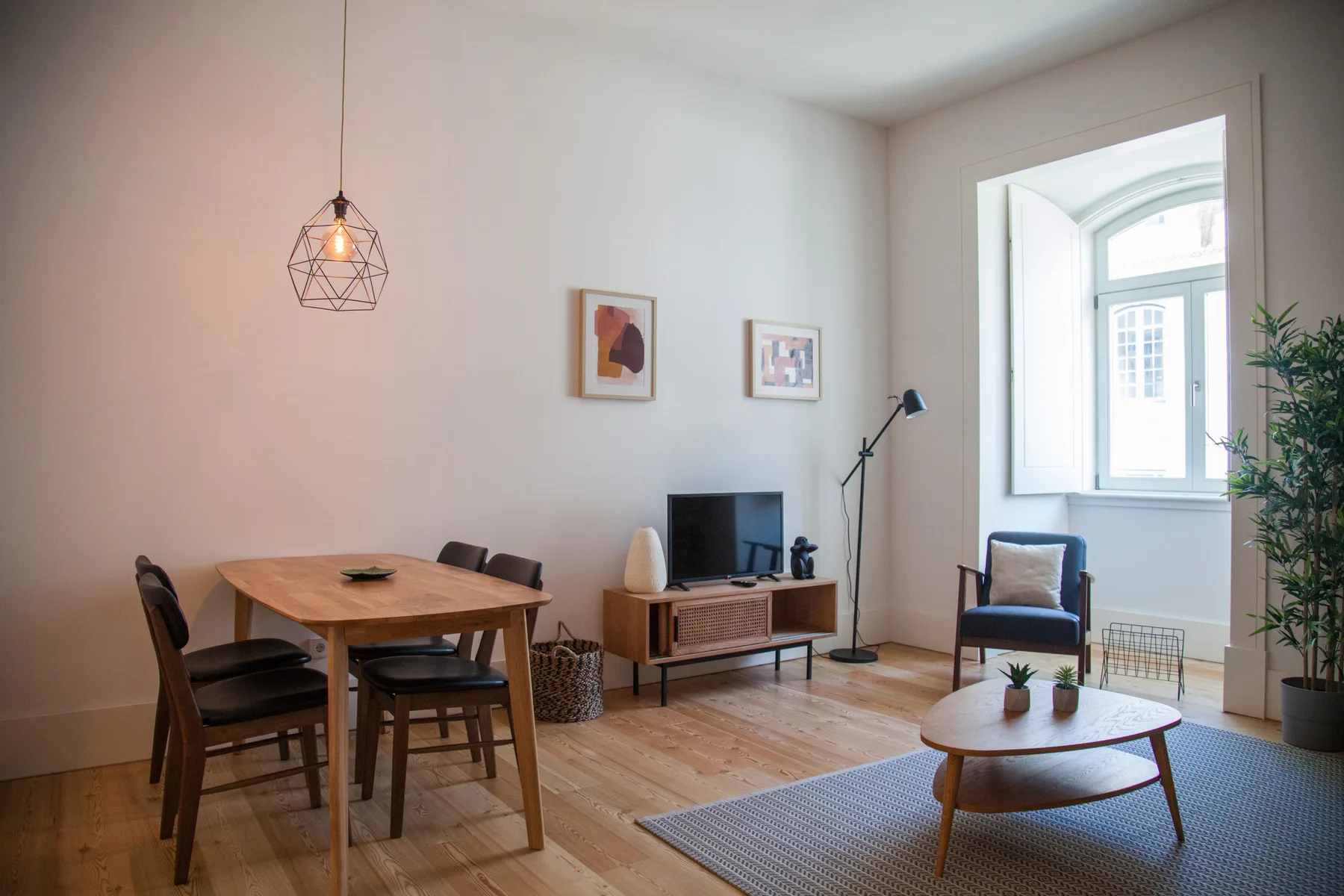 Una sala de estar luminosa con una mesa de comedor de madera y asientos.