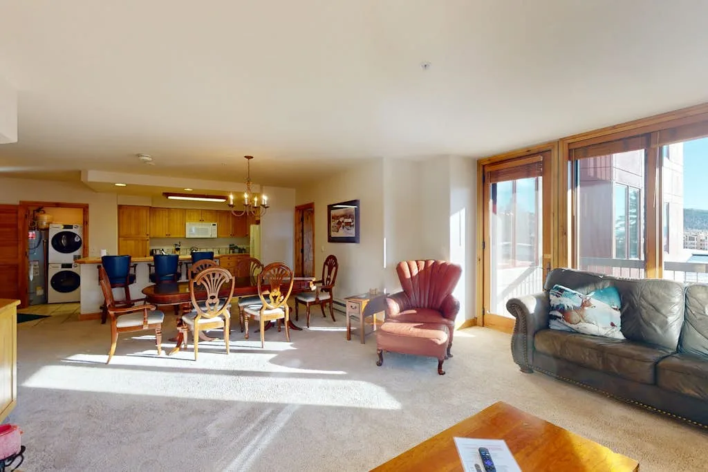 An open-plan living and dining area with seating beside large windows.
