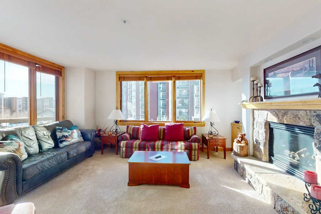A bright living room with seating, a coffee table, and a fireplace.