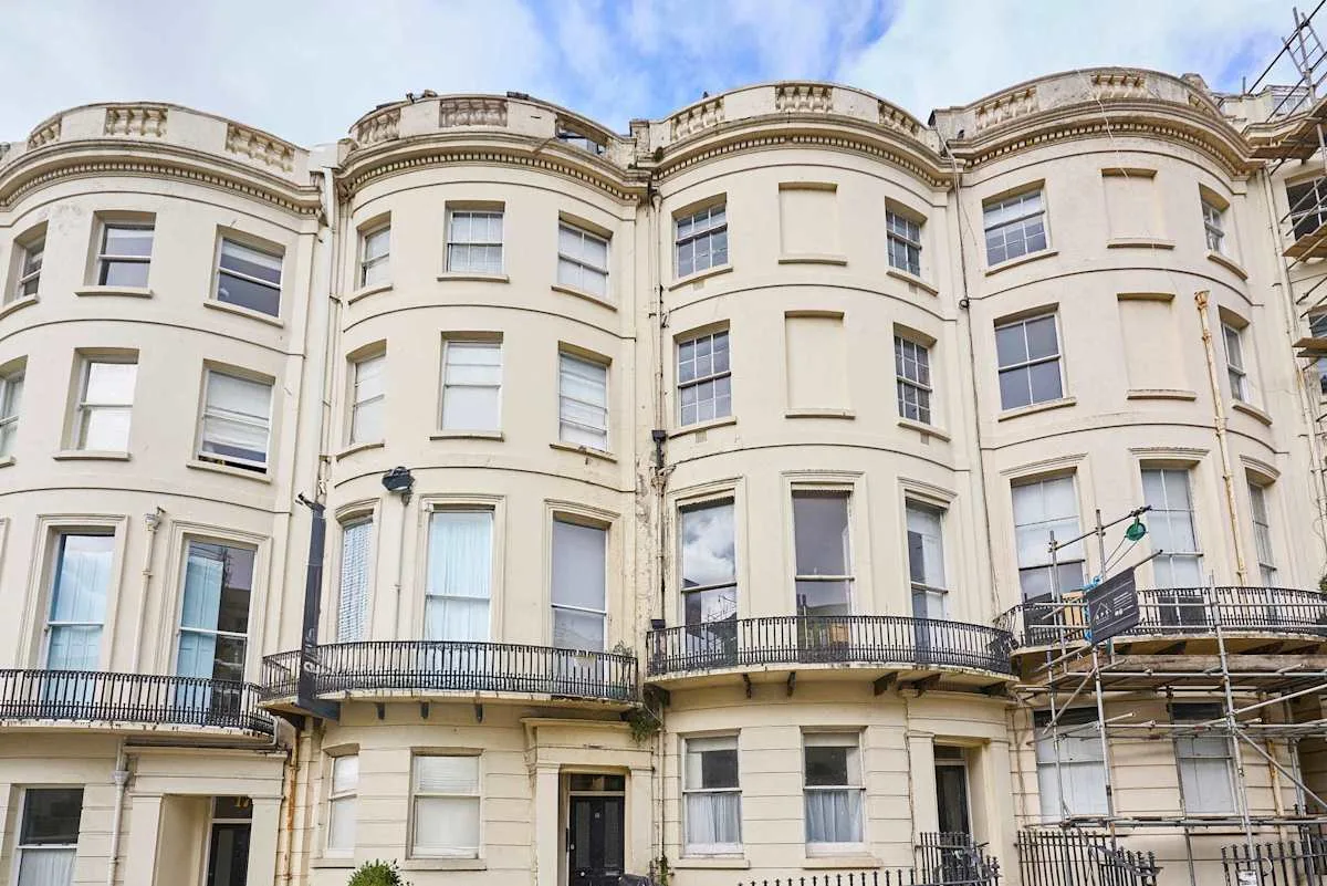 A row of pale terraced buildings with curved bay windows and balconies.