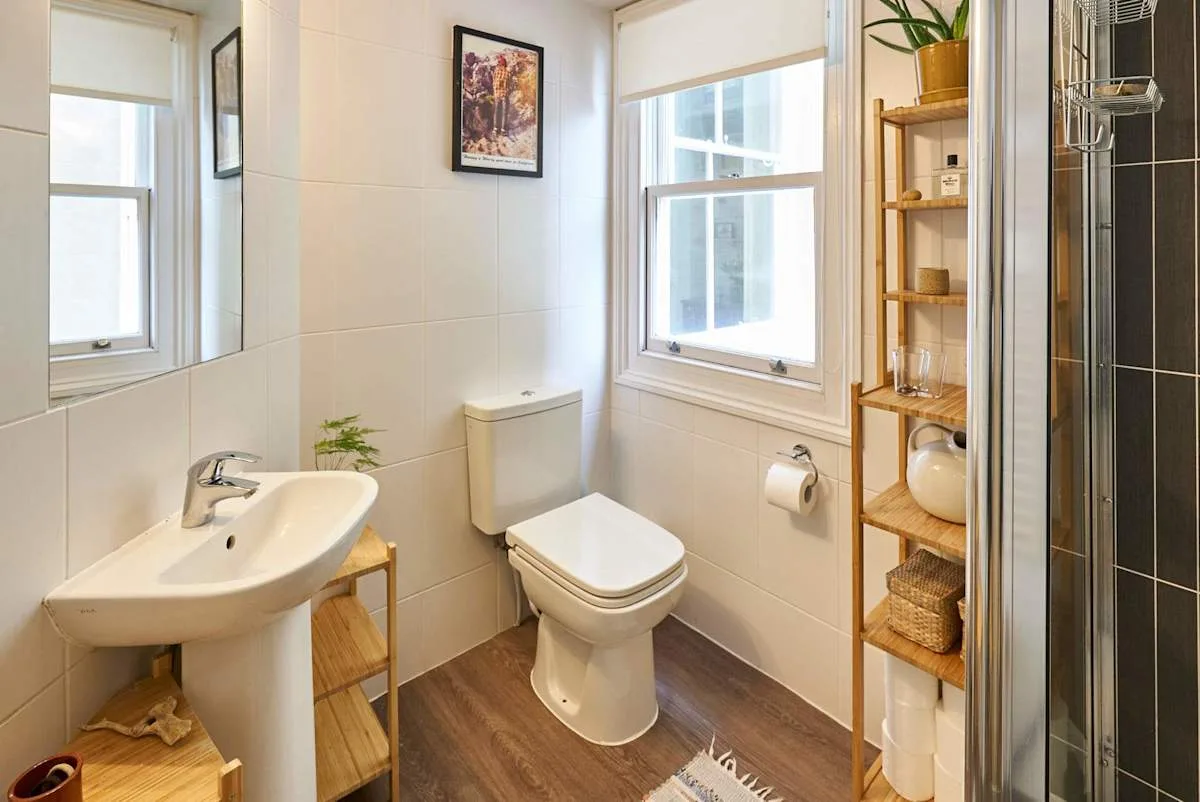 A bathroom with a sink, toilet, and window.