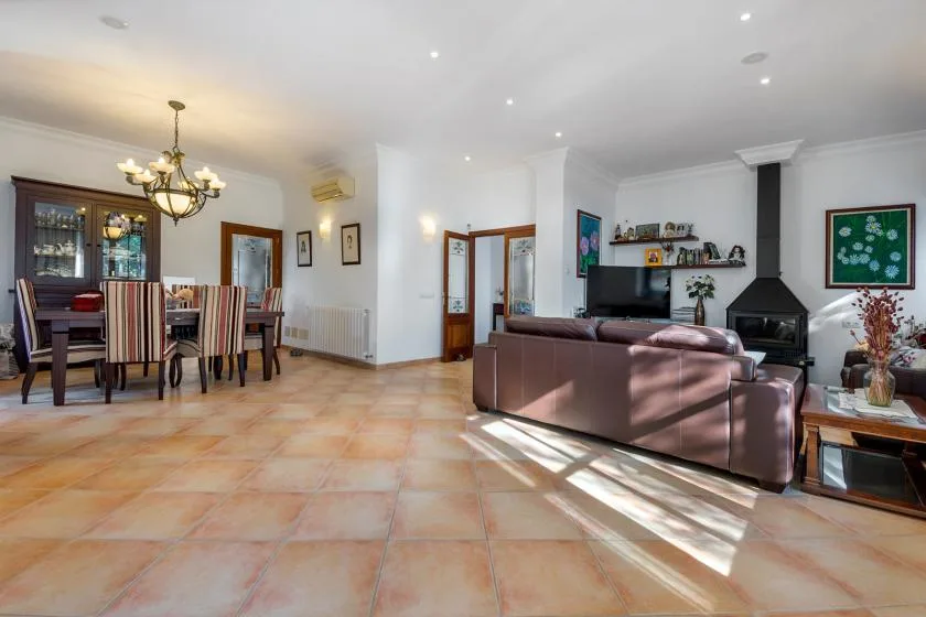 Una sala-comedor diáfana con televisión y chimenea.