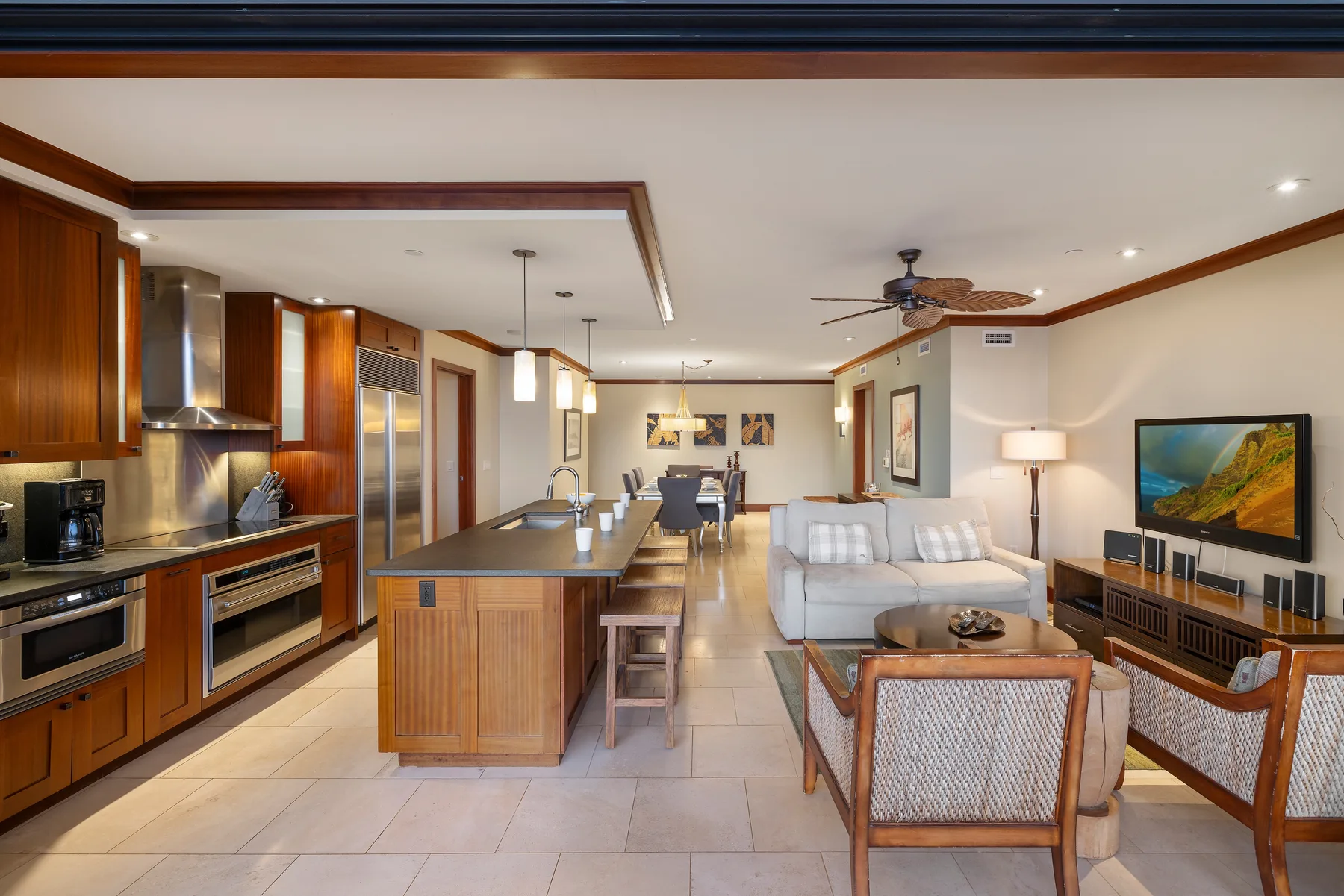 Cocina y sala de estar de planta abierta, con una isla central y asientos.