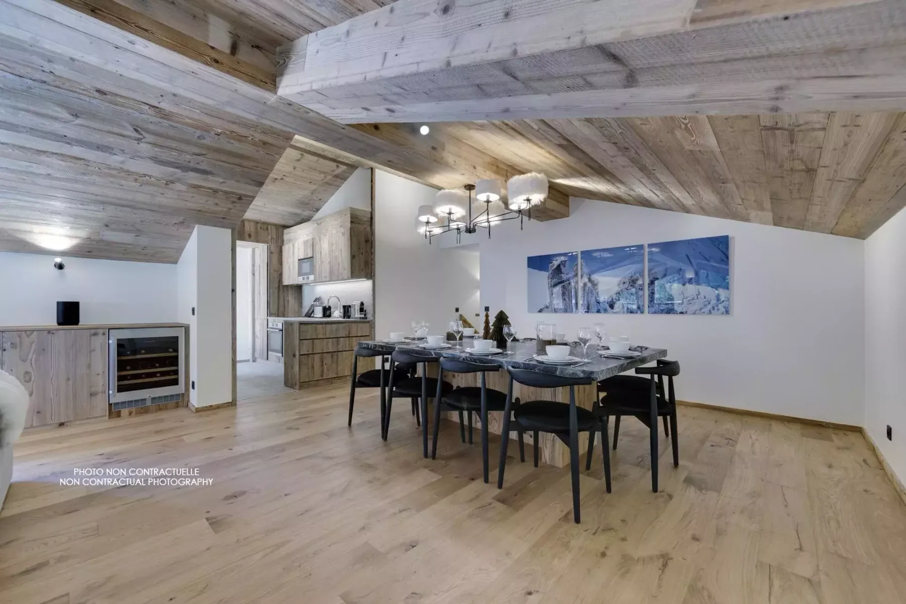 A dining area with a long table and chairs beneath a wood-paneled ceiling.