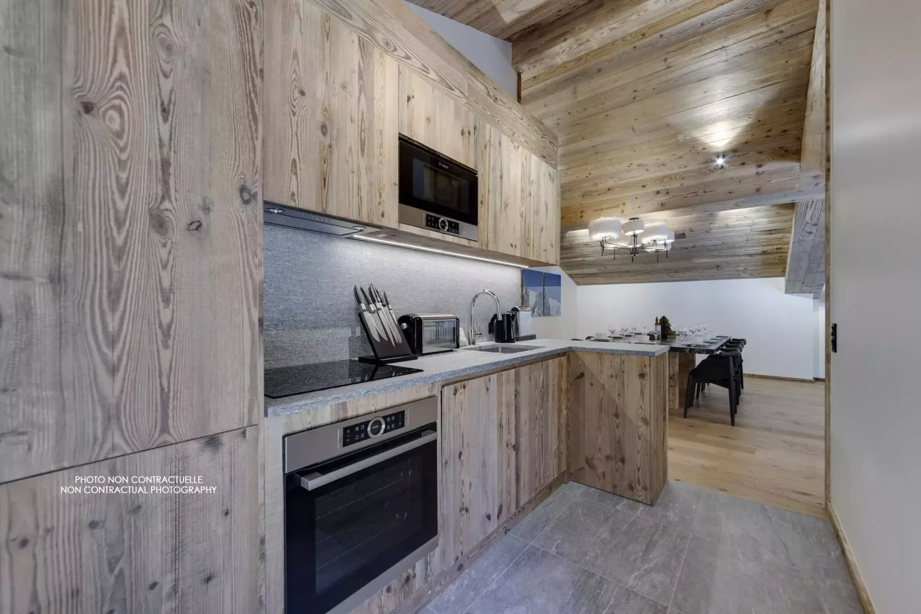A wood-paneled kitchen with built-in appliances and a dining area.