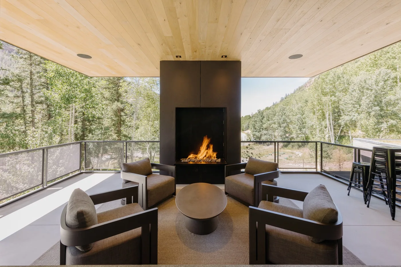 Una sala exterior con asientos dispuestos alrededor de una chimenea central.