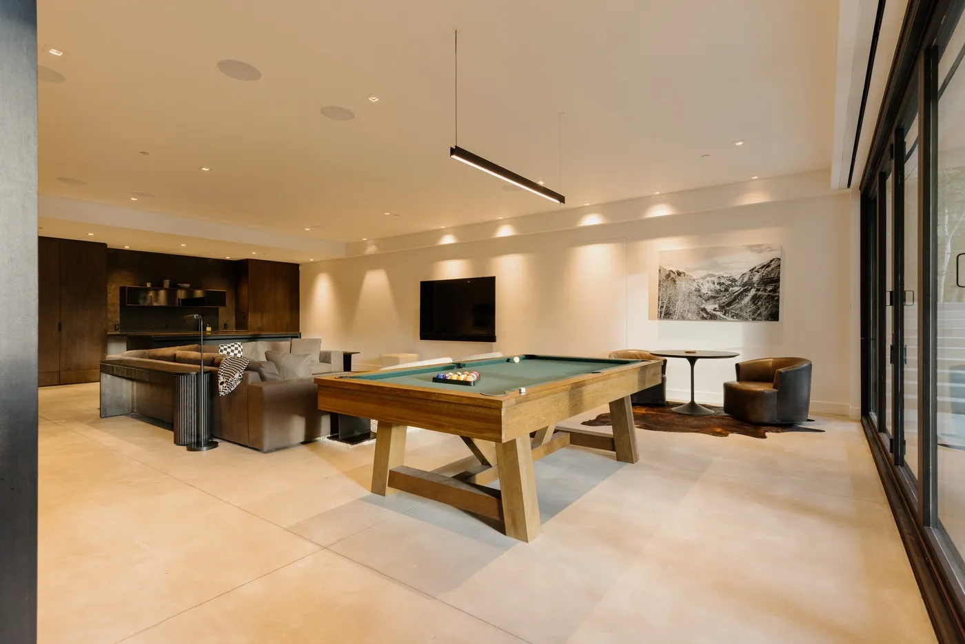 Una amplia sala de juegos cuenta con una mesa de billar, una barra y asientos.
