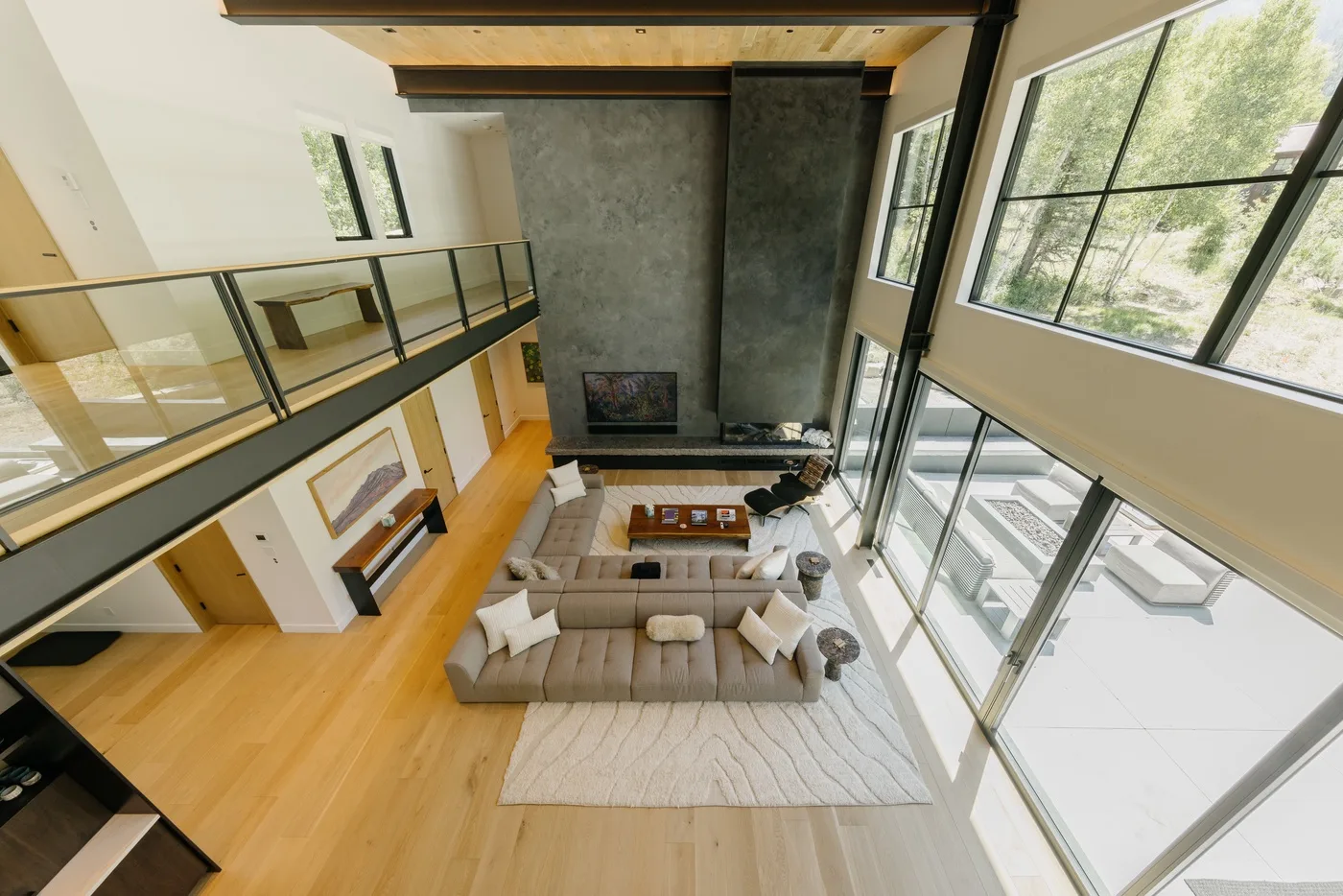 Una sala de doble altura con una zona de estar junto a grandes ventanas.