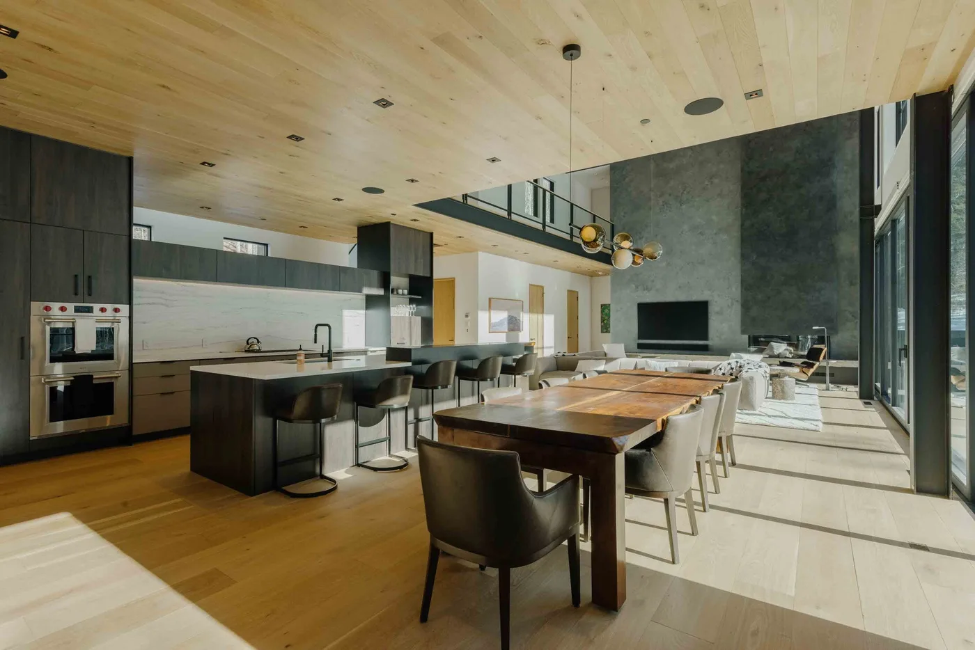 Una amplia cocina y comedor de planta abierta con una larga mesa de madera.