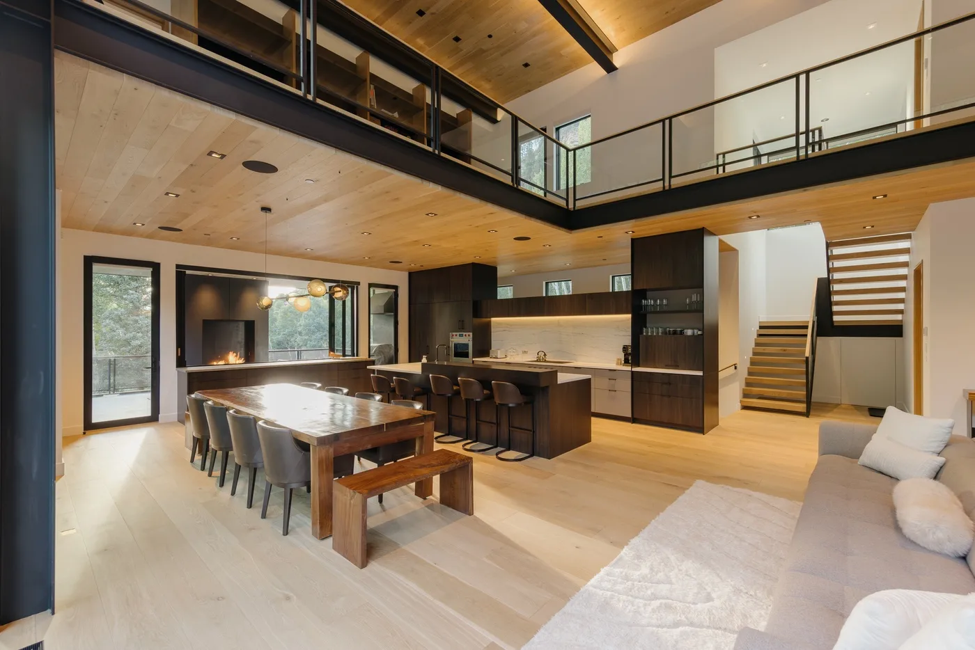 Un espacio abierto combina una mesa de comedor, una isla de cocina y una zona de estar.
